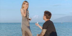 a man down on one knee proposing to woman with a diamond engagement ring from Ian Sharp Jewellery